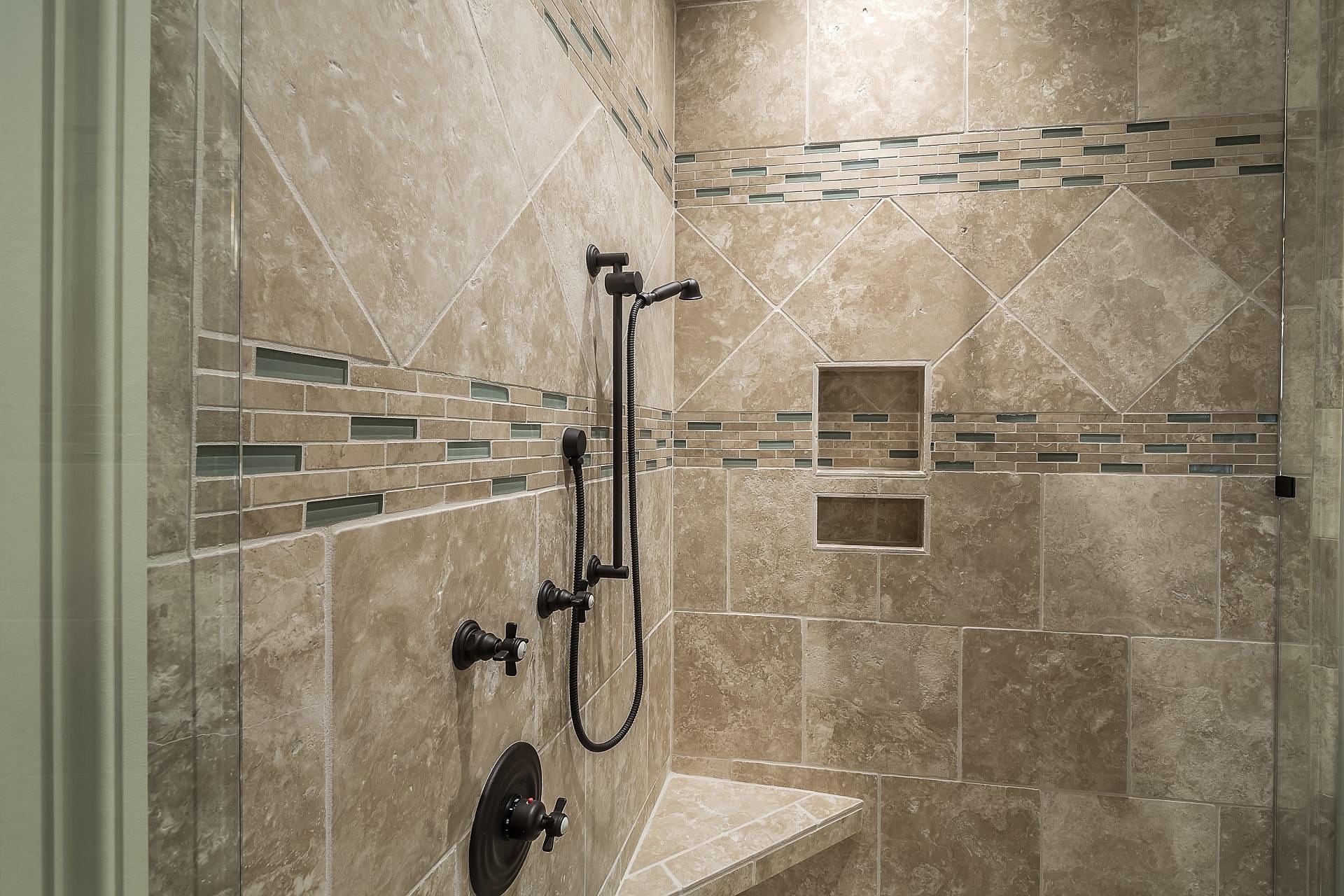Custom tiled walk-in shower with bronze fixtures